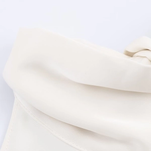 Vue détaillée du tissu blanc sans manches montrant la texture fine et les doubles coutures
