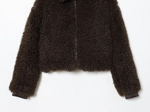 Detailed close-up of dark brown fleece texture and zipper on the short jacket