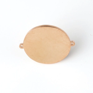 Macro detail of rose gold mirror polished round stainless steel blank charm with dual holes