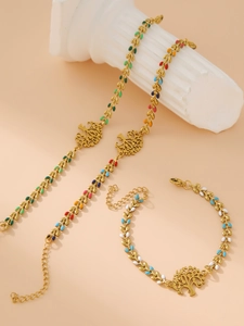 Detailed view of gold tree of life jewelry set with colorful enamel on white pillars