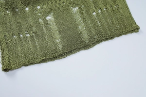 Macro view of green knitted fabric with unique hollow-out design and detailed mesh texture