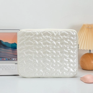 Close-up of pearl white laptop sleeve featuring heart-shaped quilting and top zipper