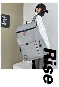 Detail view of light grey large capacity backpack with orange zipper accents for travel