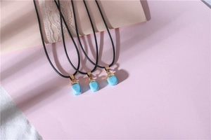 Detail view of sky blue faceted raw stone necklaces with elegant gold metal clasps