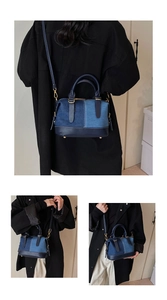 Detail of denim patchwork Boston bag featuring leather trim and gold hardware