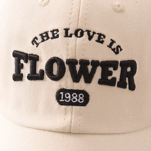 Gros plan détaillé de la casquette en coton crème avec broderie noire lettrage 1988