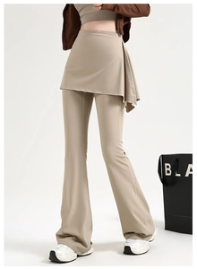 Détail du pantalon de yoga évasé beige avec surjupe et surpiqûres décoratives blanches
