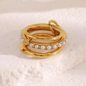Macro shot of 18K gold plated triple layered ring with micro pearls on stone background