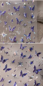 Detail of holographic purple butterfly nail stickers with metallic gold stars and gems