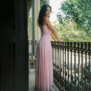Detail of elegant pink chiffon halter dress featuring pleated textures and backless design