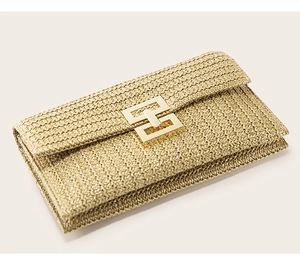 Detail of woven straw clutch bag showing a textured beige finish and golden metal lock