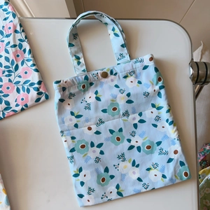 Detail of floral cotton tote bag with metal snap closure and blue flower pattern