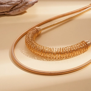 Vue macro détaillée de la texture métallique du collier à double couche à ressort doré