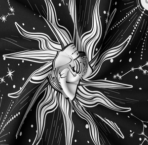 Close-up of celestial tapestry fabric showing sun and star patterns in a spiral fold