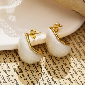 Close-up of 18k gold plated square earrings with white resin inlay on vintage book