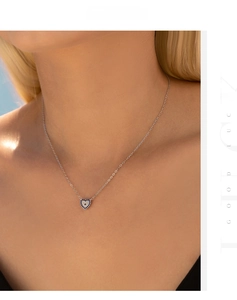 Close-up of heart-shaped S925 silver necklace with blue and white crystals on model