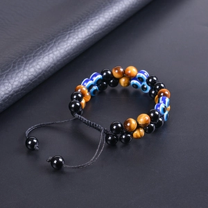 Détail du bracelet double couche en œil de tigre et œil bleu sur fond sombre