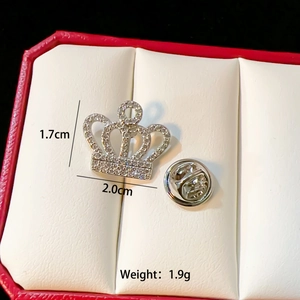 Macro shot of silver crown brooch with rhinestones and size details in a jewelry box