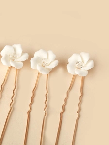 Detailed set of three gold U-shaped hairpins with white ceramic flowers and crystals