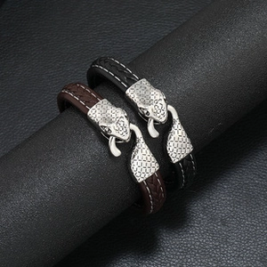 Detail of multi-layer braided leather bracelets in black and brown with silver snake head clasp