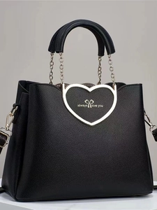Black pebbled leather tote bag featuring heart metal hardware and chain straps