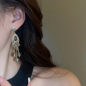 Detail of vintage bohemian drop tassel earrings featuring grey teardrop stones and crystals