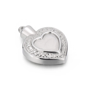 Vue macro du pendentif médaillon cœur en argent avec motifs gravés et bouchon à vis