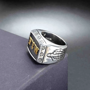 Macro view of vintage stainless steel punk ring with golden FTW lettering and skull detail