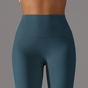 Close-up of high-waist teal blue yoga pants with seamless texture and peach lift design