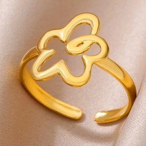 Close-up of golden hollow flower ring with cubic zirconia on beige silk fabric