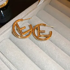 Elegant gold hollow C-shaped earrings with F letter design in a velvet box