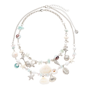 Double layer ocean necklace with starfish shell charms and faux pearls on white background