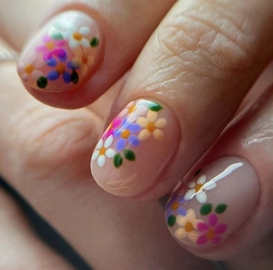 Macro shot of short square press-on nails with colorful floral patterns and glossy finish
