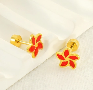 Makroaufnahme von roten Emaille-Blumenohrringen mit goldenem Metallsockel und Schraubverschluss