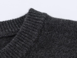 Detailed macro view of dark grey ribbed knit cardigan with soft fuzzy wool texture
