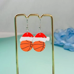 Detail of acrylic basketball earrings with red Christmas hats on a gold display stand