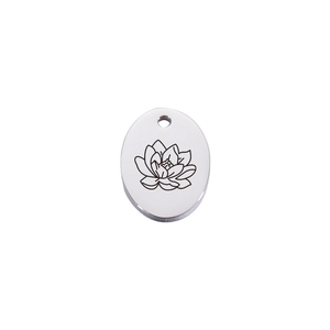 Detailed macro view of an oval stainless steel pendant with engraved lotus flower design
