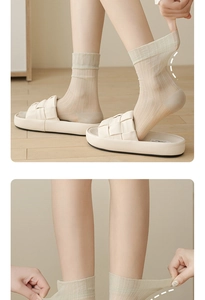 Detail showing high elasticity of breathable mesh calf socks in light beige color