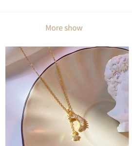 Artistic detail of gold star and crescent moon necklace with rhinestones on ceramic tray