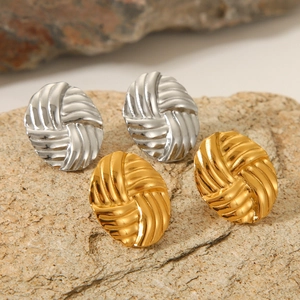 Twisted woven oval stud earrings in 18K gold and silver finish on natural rock