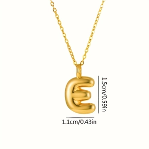 Dettaglio del ciondolo a lettera E dorata con le dimensioni di 1,5 cm per 1,1 cm