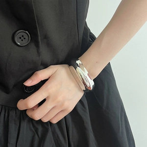 Close-up of wide silver double-layer metal bangle with high glossy finish on wrist