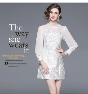 Close-up of white floral embroidery and beadwork on a vintage style cocktail dress
