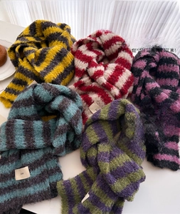 Close-up of the thick knit wool texture and color-block striped patterns on a warm scarf