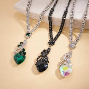 Détail de colliers avec pendentifs en cœur de luxe sertis de strass vert émeraude et cristal