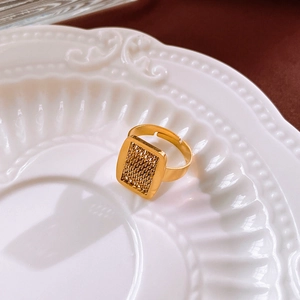 Detailed macro view of golden square woven texture ring on a ceramic plate