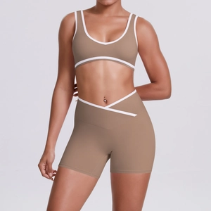 Detail of V-shaped high-waisted yoga shorts and sports bra with white piping trim