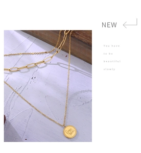 Close-up of double-layer gold chain necklace with Carpe Diem engraved coin pendant