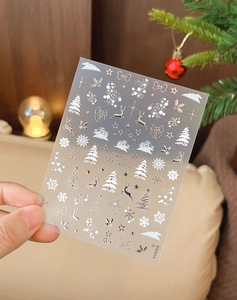 Gros plan de stickers à ongles de Noël or et blanc avec motifs de rennes et de flocons