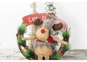 Detail of Christmas reindeer wreath with LED lights and Let it snow sign on rattan base